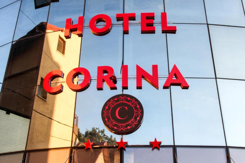 ein Corona-Schild eines Hotels an der Seite eines Gebäudes in der Unterkunft Hotel Corina in Borsa
