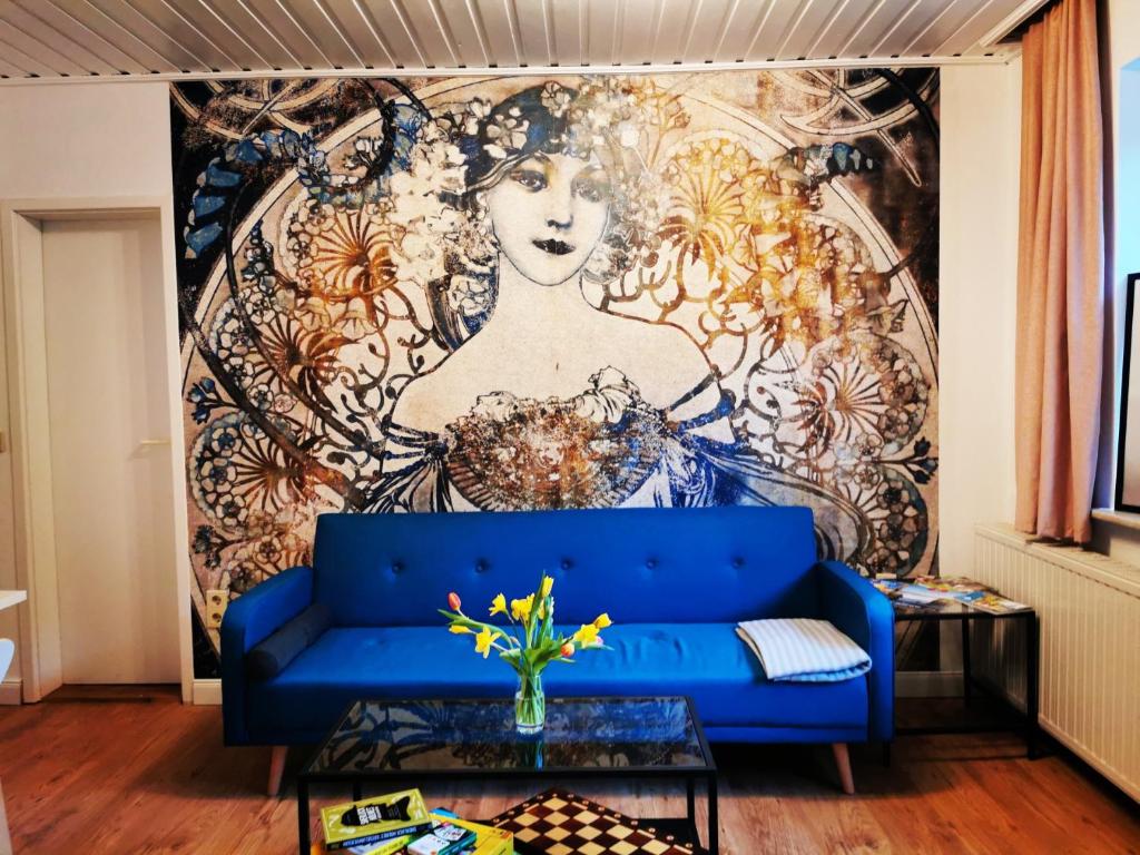 sala de estar con sofá azul frente a un mural en Villa Rapunzel, en Rathen