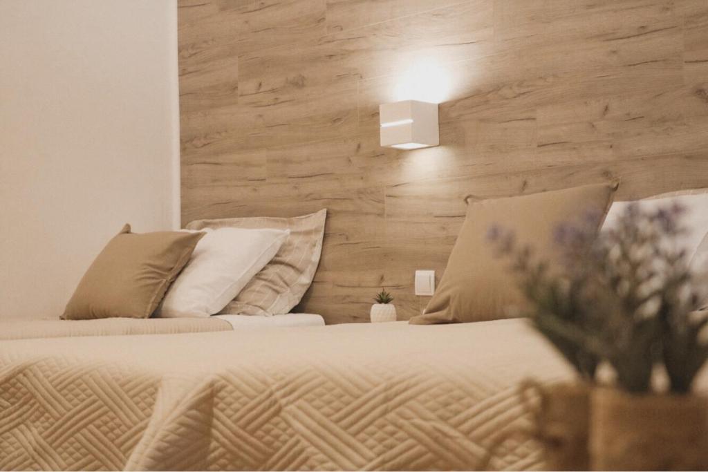 een slaapkamer met een bed met een houten muur bij Hotel Orion in Vodice