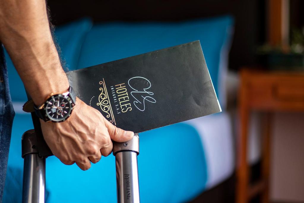 a person holding a sign on a cane at Hotel Valle de Pubenza in Popayan