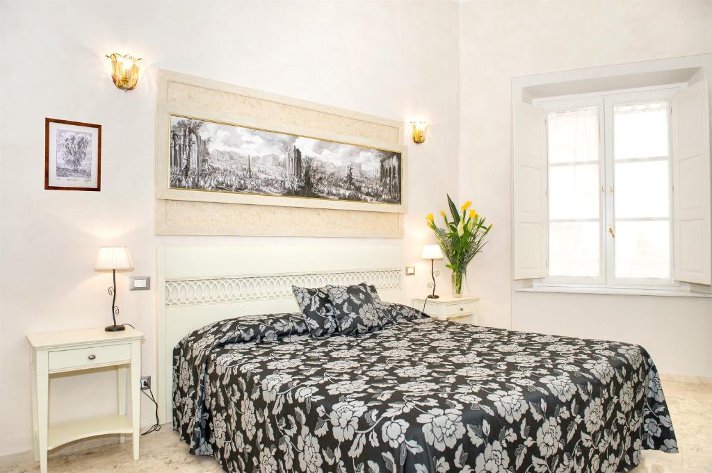 Schlafzimmer mit einem schwarzen und weißen Bett und einem Fenster in der Unterkunft Relais Dei Mercanti B&B And Suites in Pisa