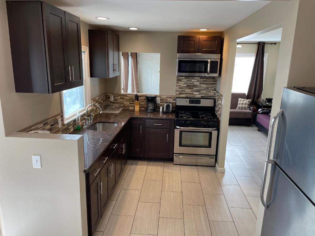 a kitchen with stainless steel appliances and brown cabinets at Newly Renovated 2 Bedroom House in Seaside Heights