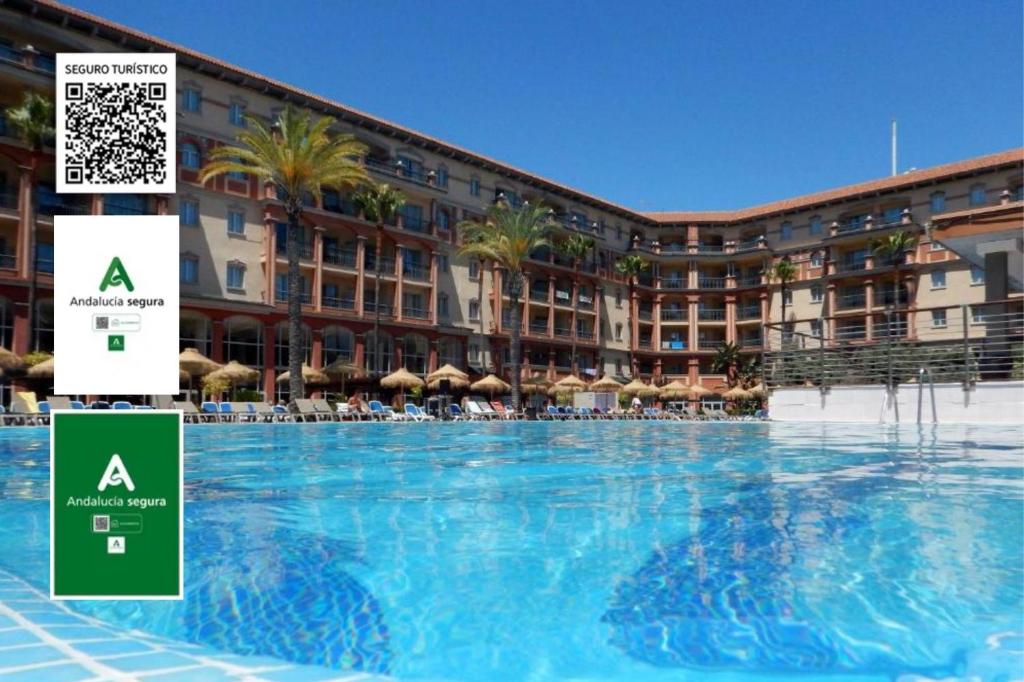 une grande piscine en face d'un hôtel dans l'établissement Ohtels Islantilla, à Islantilla