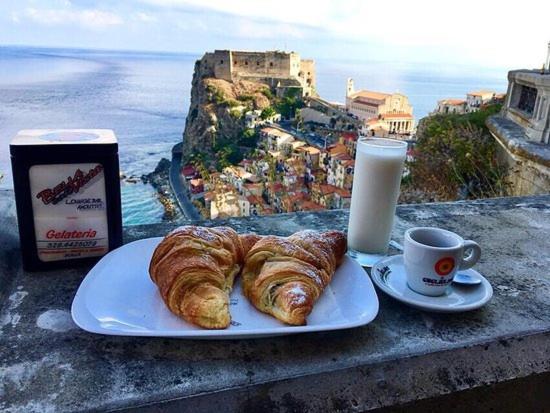einen Teller Croissants und eine Tasse Kaffee auf einem Felsvorsprung in der Unterkunft B&B La Bastia in Scilla
