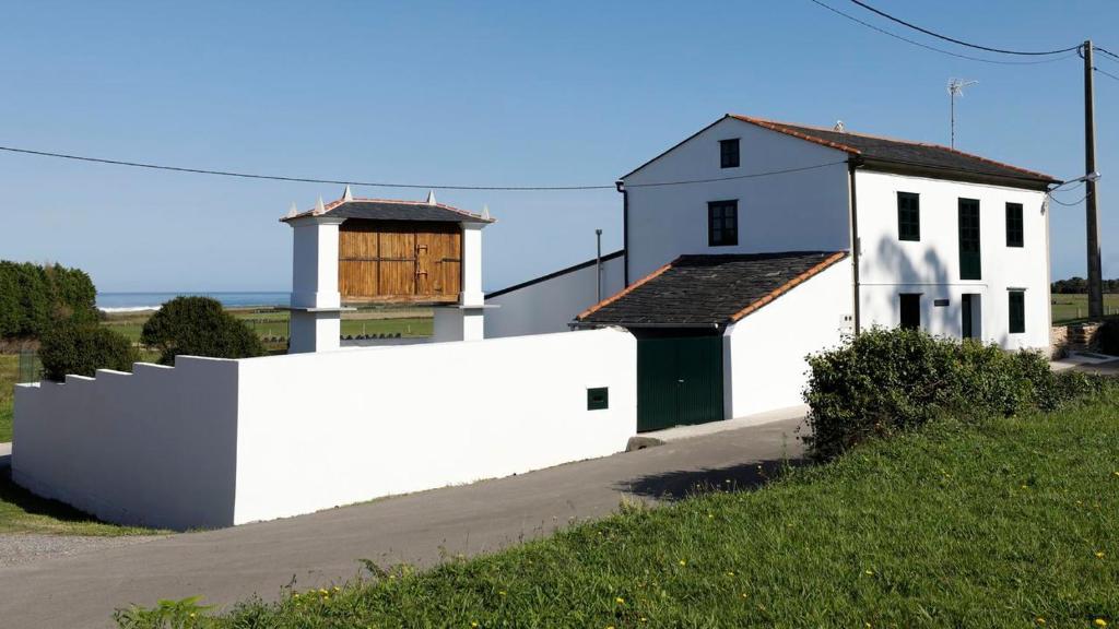 a white house with a white fence next to a building at A Minguxaina in Ribadeo