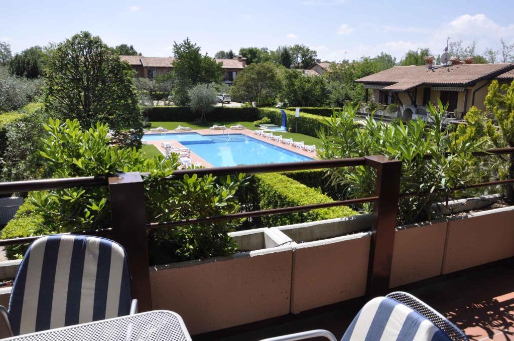 een balkon met stoelen en een zwembad bij Apartment in Lazise - Gardasee 40851 in Lazise