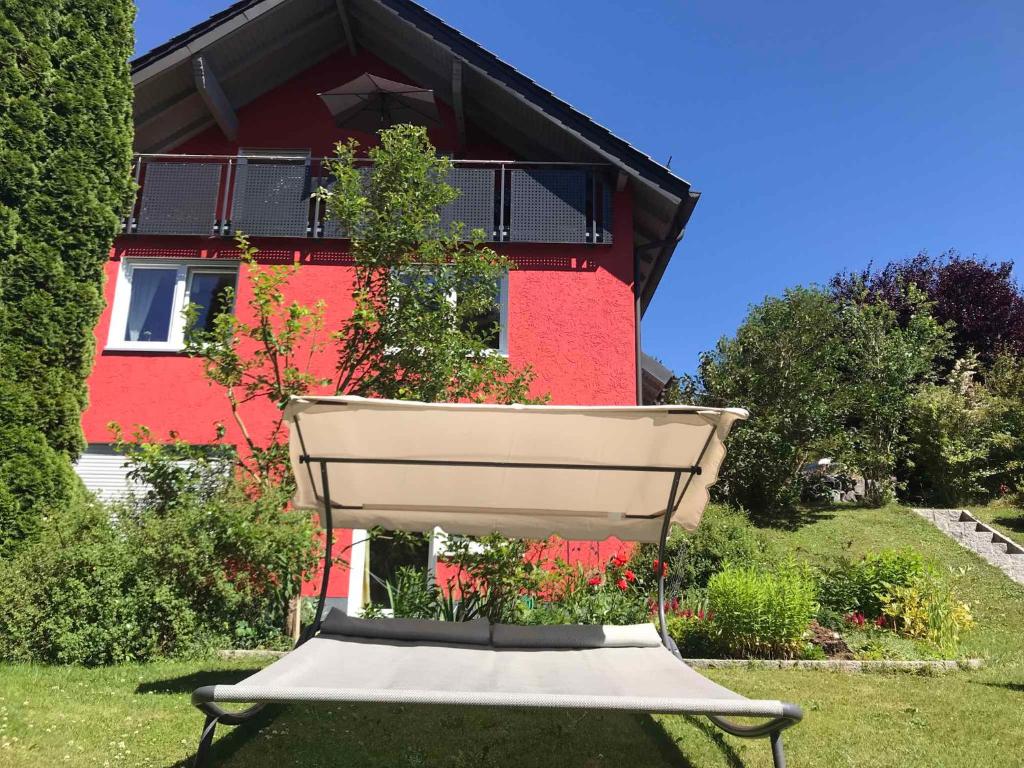 uma casa vermelha com um banco à frente em Apartment in Schauenstein - Franken 40833 em Schauenstein