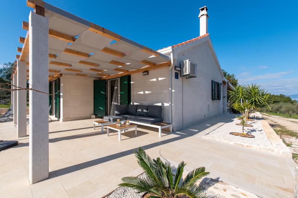 a patio of a house with a couch and a table at Villa Rogač in Sutivan