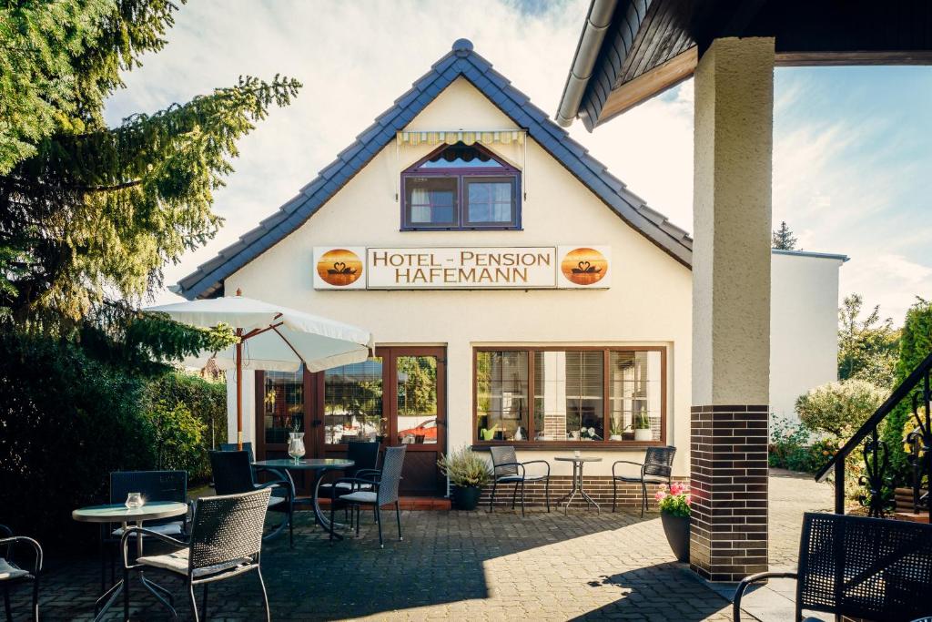 a restaurant with tables and chairs in front of a building at Hotel-Pension Hafemann in Senftenberg