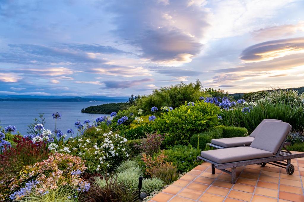 a chair sitting on a patio with a view of the water at Lake Vista Lodge in Taupo