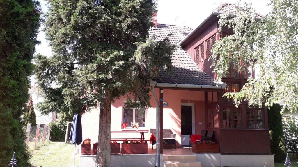 uma casa vermelha e branca com uma mesa e cadeiras em Holiday home in Balatonmariafürdo 40806 em Balatonmáriafürdő