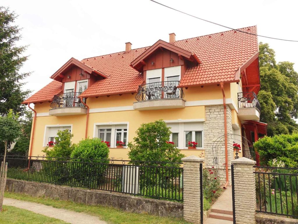 una casa amarilla con una valla delante de ella en Apartments in Balatonbereny 40425, en Balatonberény