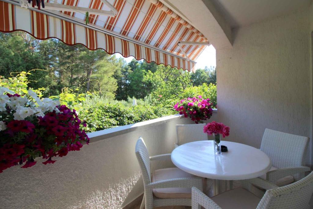 a white table and chairs on a balcony with flowers at Apartment in Porec/Istrien 40339 in Poreč