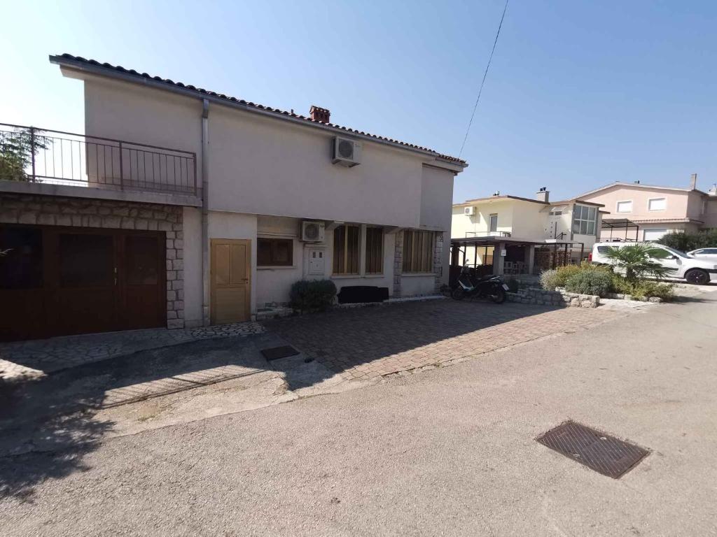 ein weißes Haus mit einem davor geparkt in der Unterkunft Apartment in Crikvenica 40895 in Crikvenica