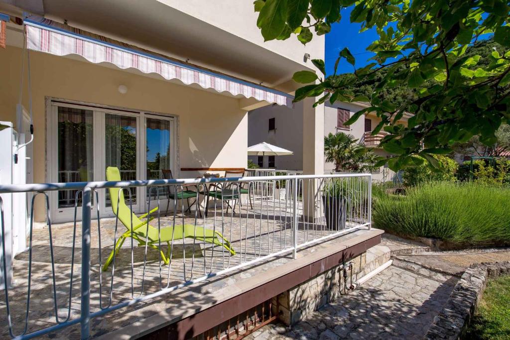 a house with a patio with chairs and a table at Apartments in Moscenicka Draga 34827 in Mošćenička Draga