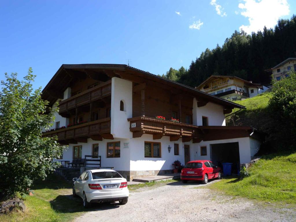 a house with two cars parked in front of it at Apartments in Kaltenbach/Zillertal 751 in Kaltenbach
