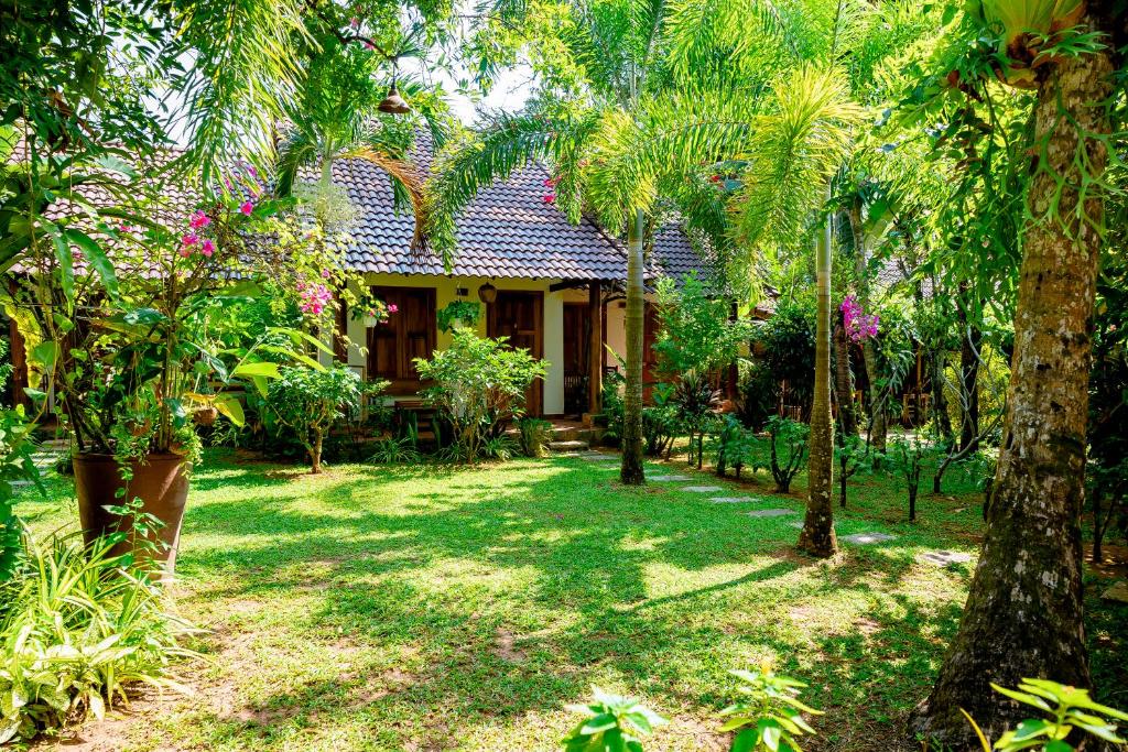a house in the middle of a yard with trees at La Mer Resort, Phú Quốc in Phú Quốc