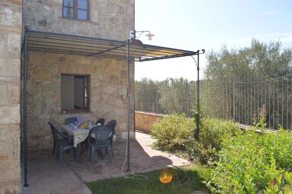 a patio with a table and chairs under a pergola at Apartment in Asciano/Toskana 24110 in Asciano