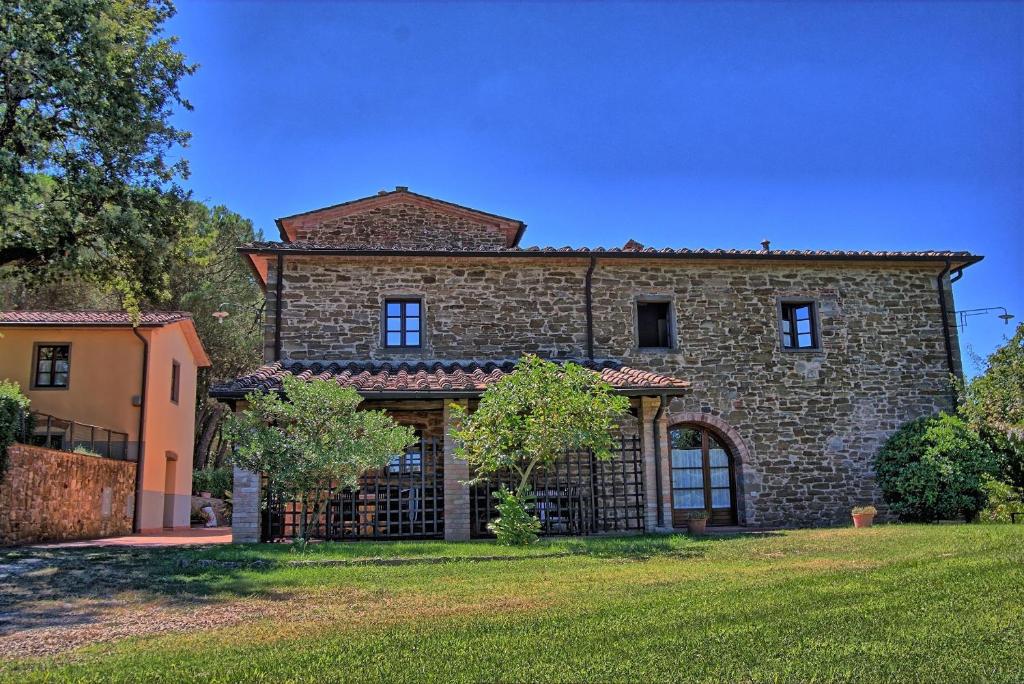 a large stone house with a large yard at Villa Il Prato in San Pancrazio