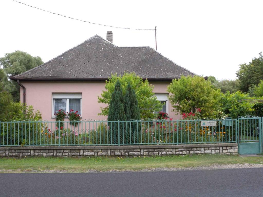 a pink house with a fence in front of it at Holiday home in Balatonfenyves 38166 in Balatonfenyves