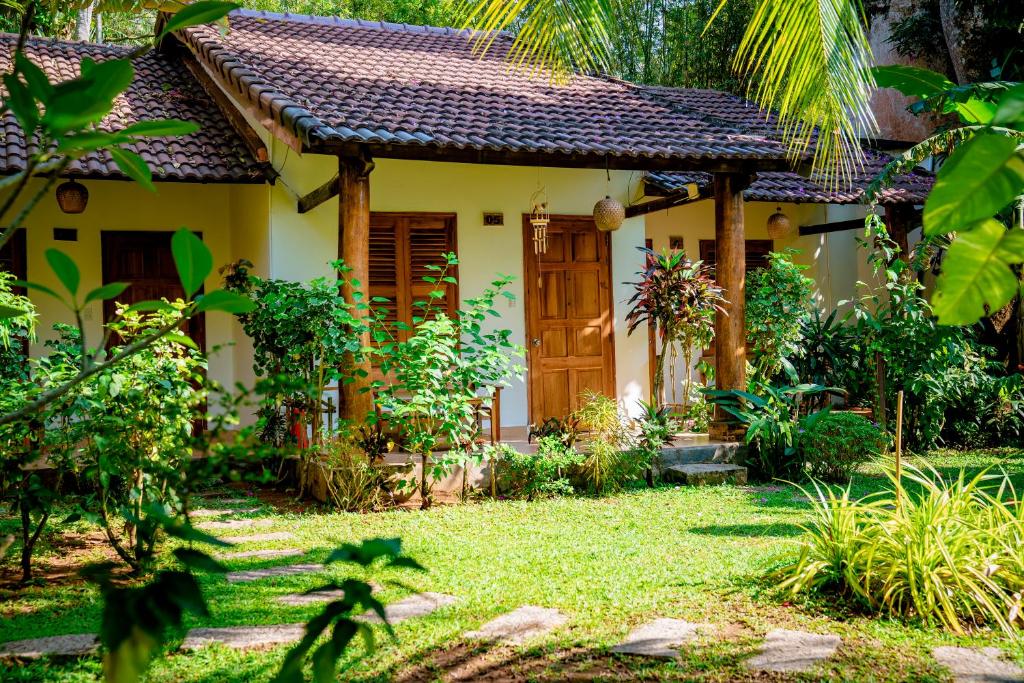 a house with a door in a garden at La Mer Resort, Phú Quốc in Phú Quốc