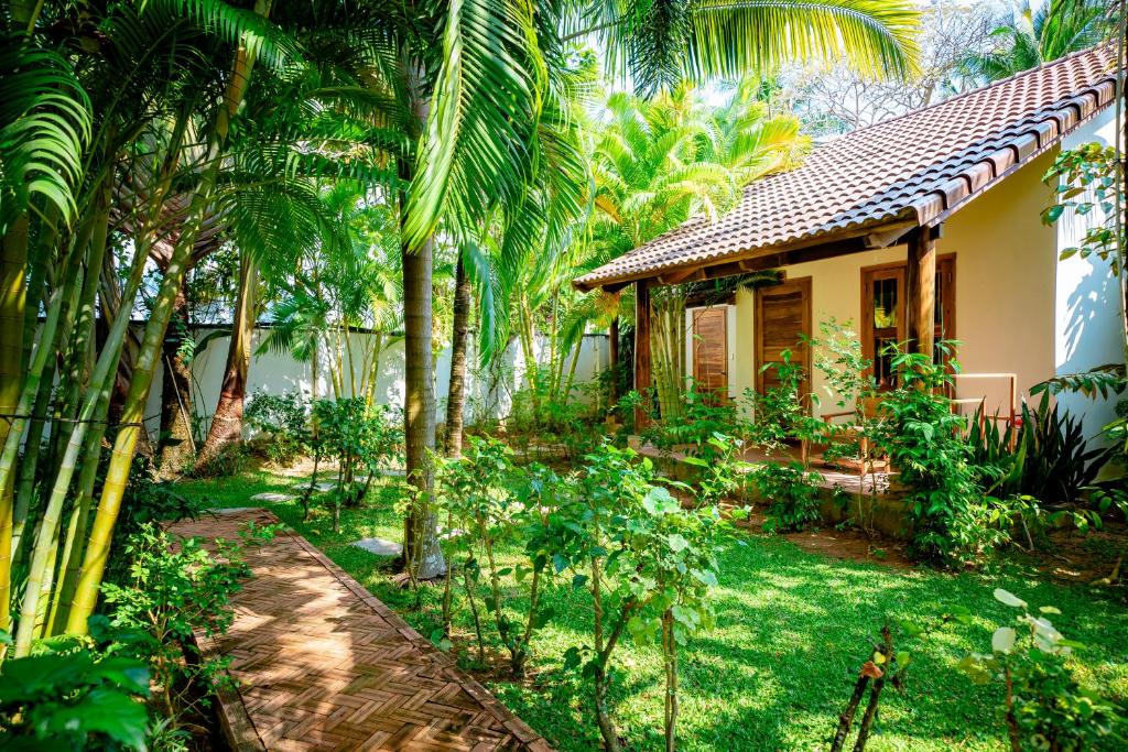 a house with palm trees in front of a yard at La Mer Resort, Phú Quốc in Phú Quốc