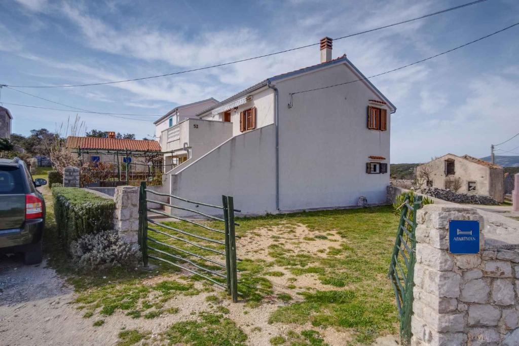 a white house with a fence in front of it at Apartment in Stivan/Insel Cres 37906 in Štivan