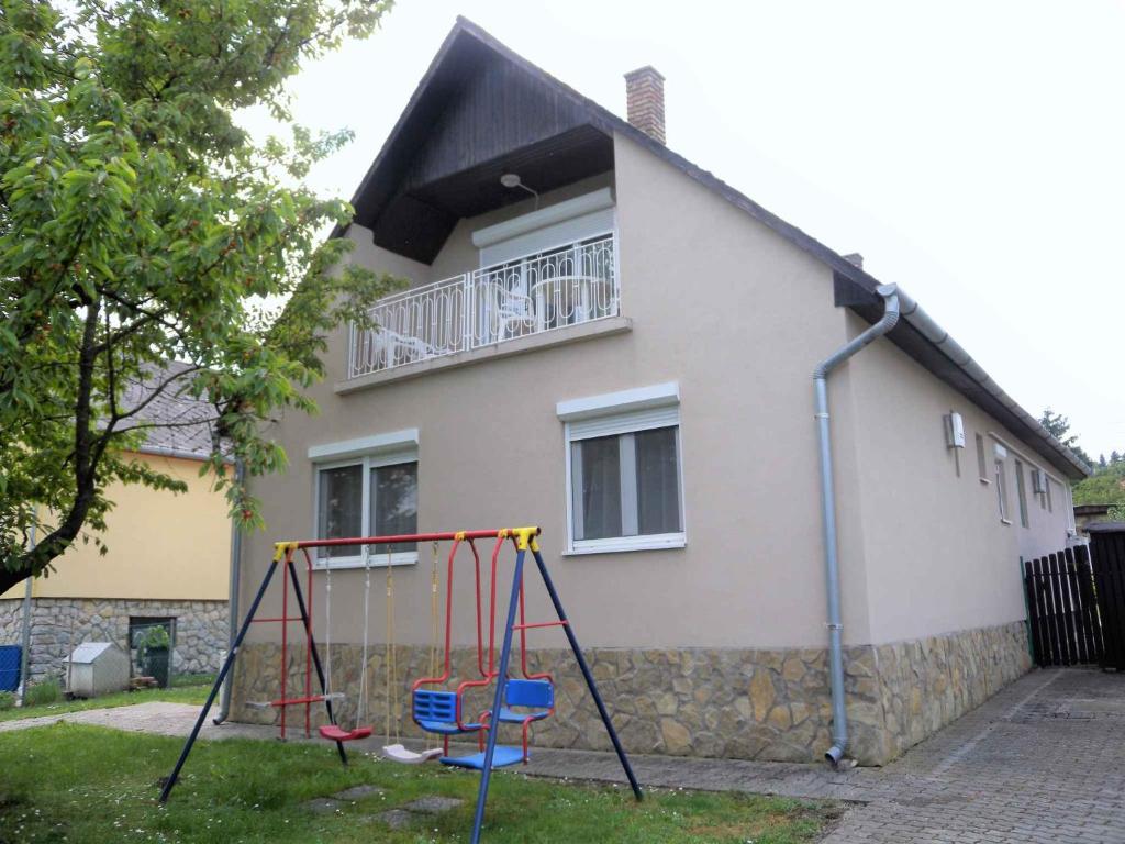 uma casa com um baloiço em frente em Holiday home in Fonyod/Balaton 38001 em Fonyód