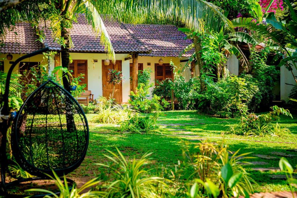 a house with a garden with a bird cage in front of it at La Mer Resort, Phú Quốc in Phú Quốc