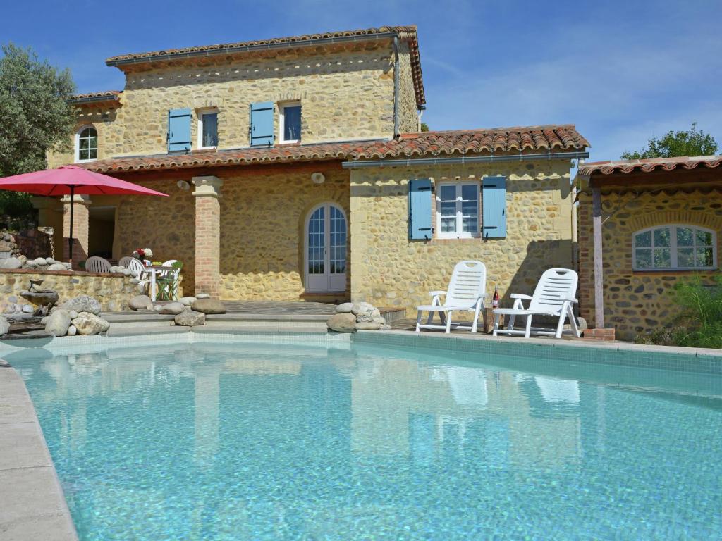 ein Haus mit zwei Stühlen und einem Pool in der Unterkunft Heritage Villa in Les Mages with Swimming Pool in Les Mages