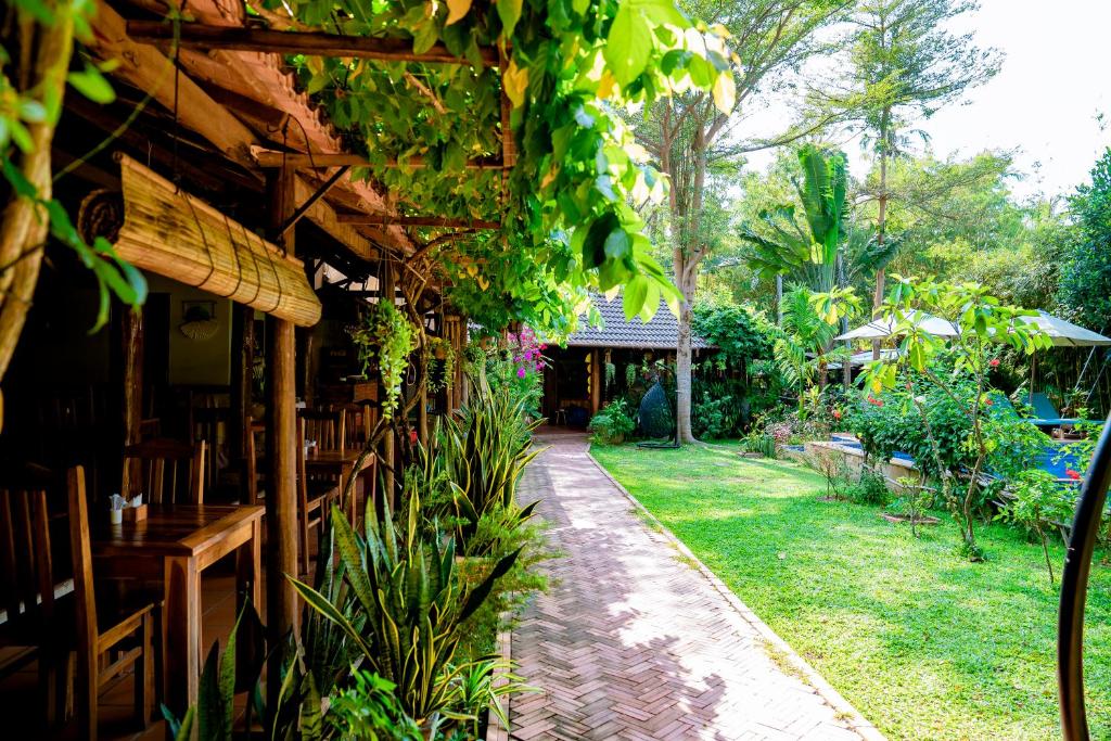 a patio of a restaurant with tables and plants at La Mer Resort, Phú Quốc in Phú Quốc