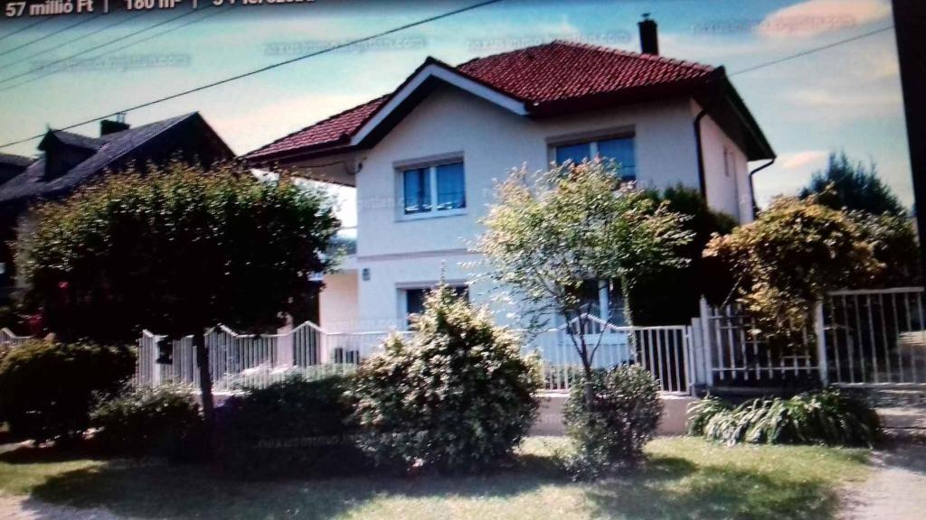 a white house with a fence in front of it at Apartment in Heviz/Balaton 36758 in Hévíz