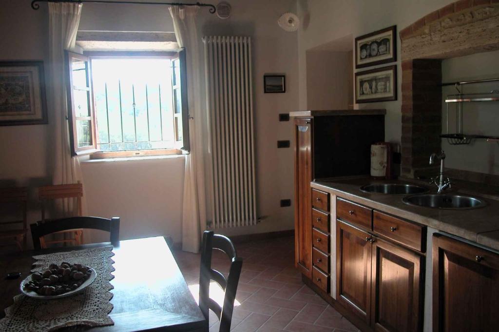 a kitchen with a table and a sink and a window at Apartments in Asciano - Toskana 24096 in Serre di Rapolano