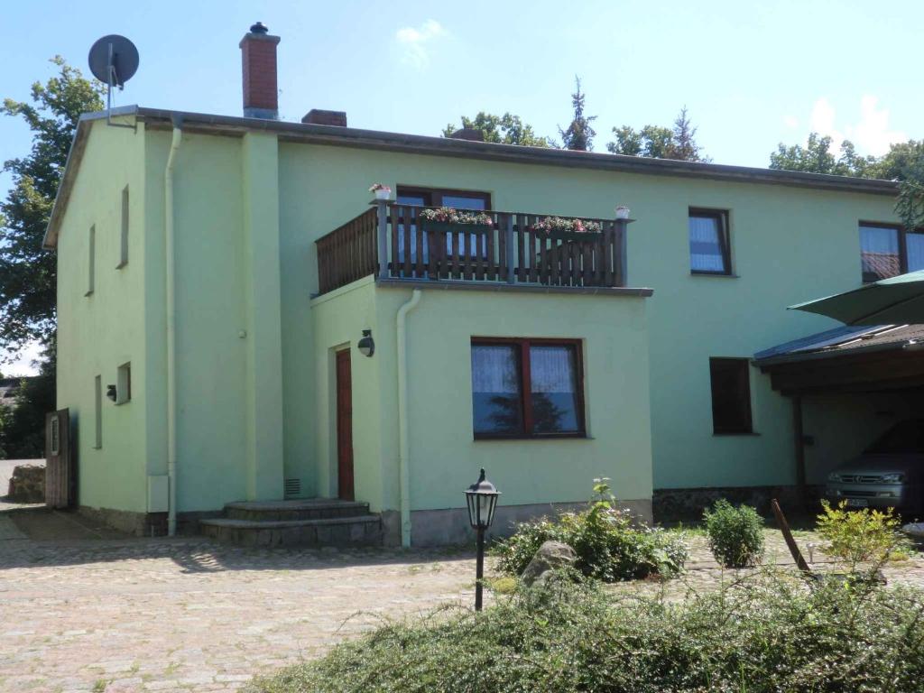 a green house with a balcony on top of it at Studio in Ribnitz-Damgarten 36833 in Ribnitz-Damgarten