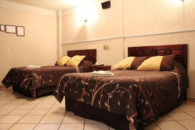 Postel nebo postele na pokoji v ubytování Feria Jalisciense