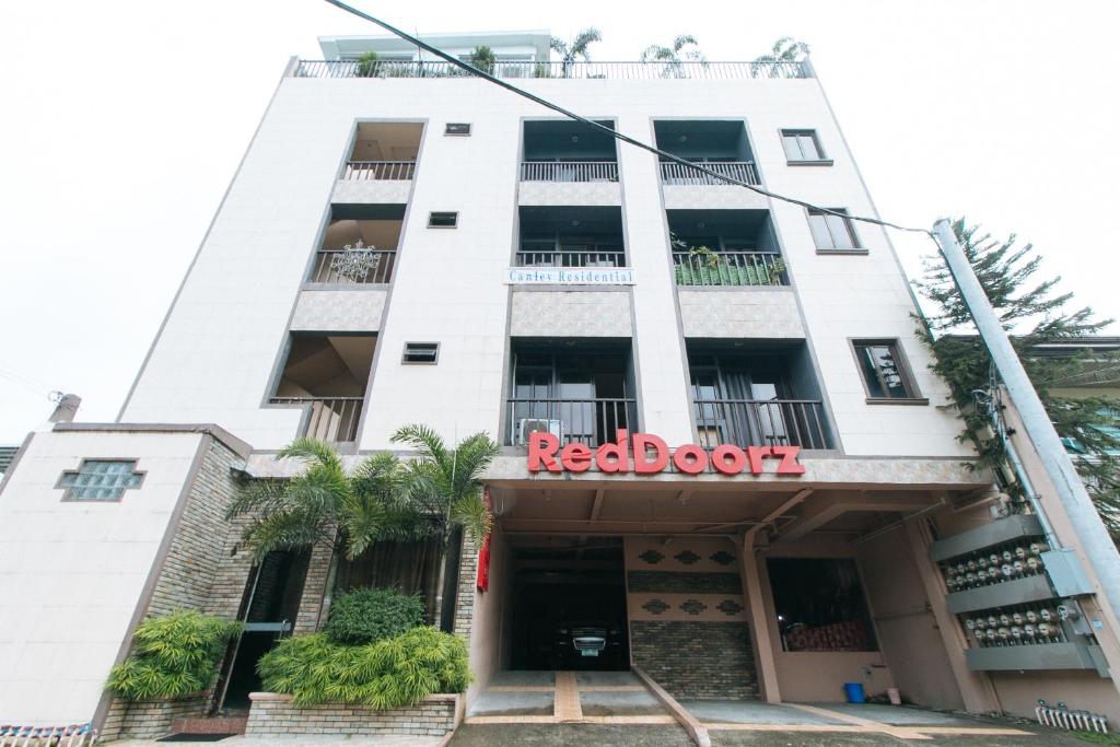Biały budynek z czerwonym napisem w obiekcie RedDoorz Plus at Canley Residential w mieście Manila