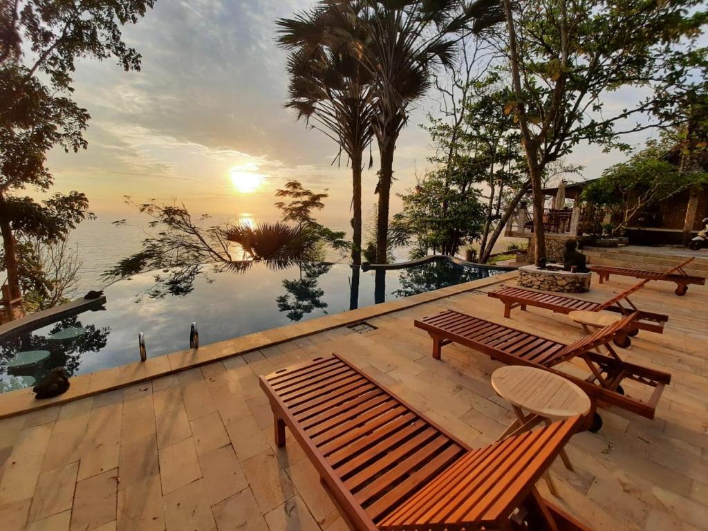 a deck with benches and a view of the water at Edge Resort, Yogyakarta in Parangtritis