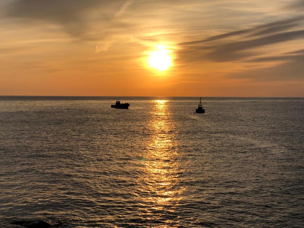 two boats in the ocean at sunset at Izu Shirada Villa 伊豆白田家 in Higashiizu