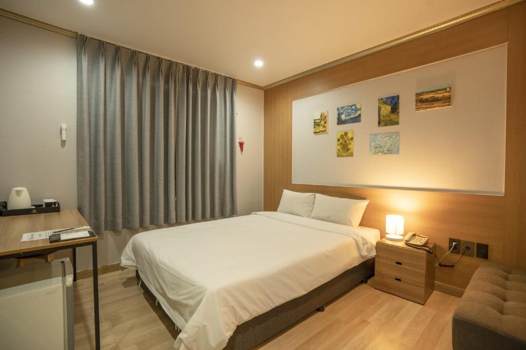 Postel nebo postele na pokoji v ubytování Jeju Stay Hotel