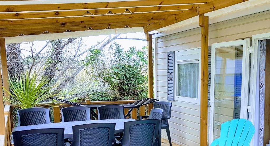 a patio with a table and chairs on a porch at Mobile home De Luxe St Cyprien in Saint-Cyprien