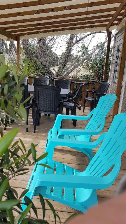 a group of blue chairs sitting on a deck at Mobile home De Luxe St Cyprien in Saint-Cyprien