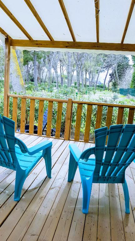 two blue chairs sitting on a wooden deck at Mobile home De Luxe St Cyprien in Saint-Cyprien