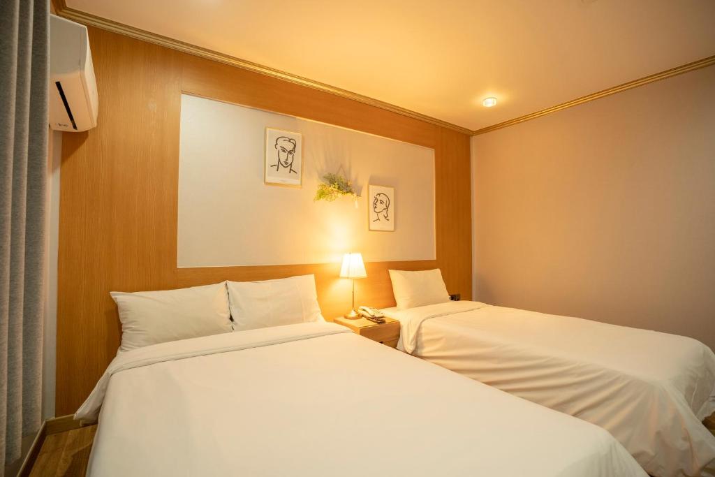 Postel nebo postele na pokoji v ubytování Jeju Stay Hotel