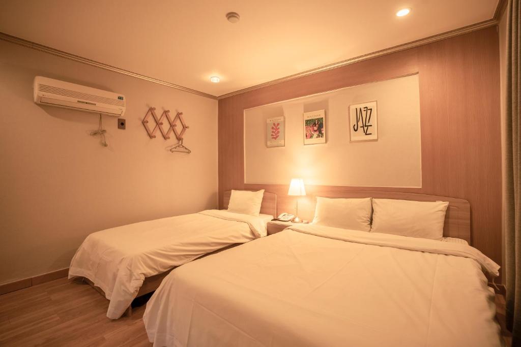Postel nebo postele na pokoji v ubytování Jeju Stay Hotel