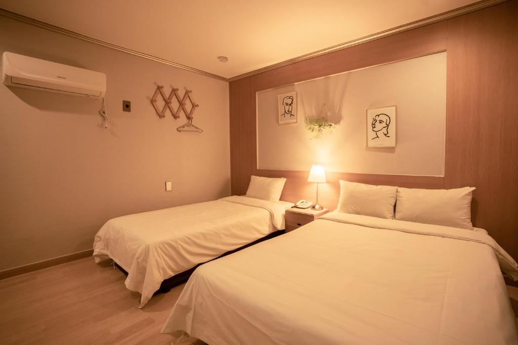 Postel nebo postele na pokoji v ubytování Jeju Stay Hotel