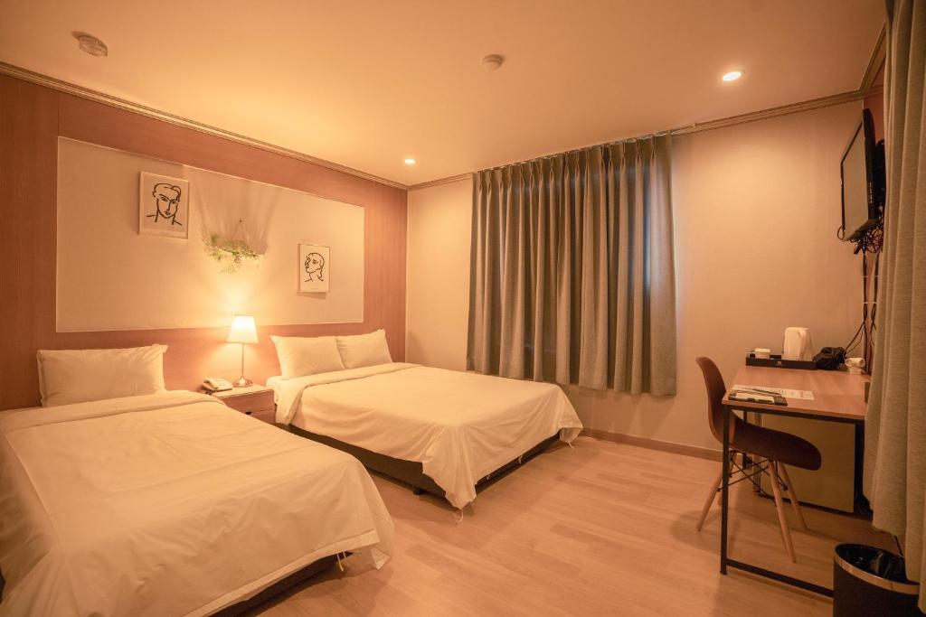 Postel nebo postele na pokoji v ubytování Jeju Stay Hotel