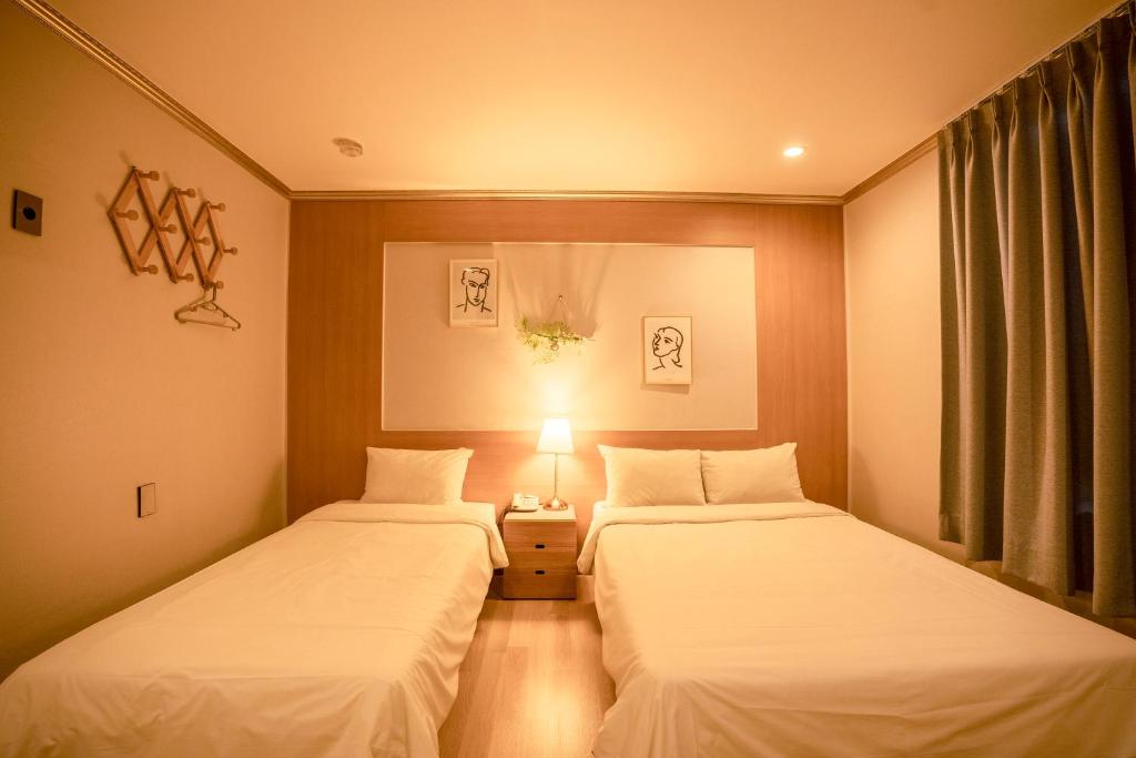 Postel nebo postele na pokoji v ubytování Jeju Stay Hotel
