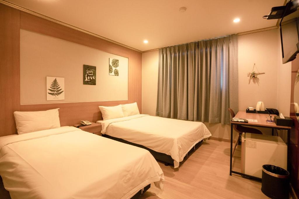Postel nebo postele na pokoji v ubytování Jeju Stay Hotel