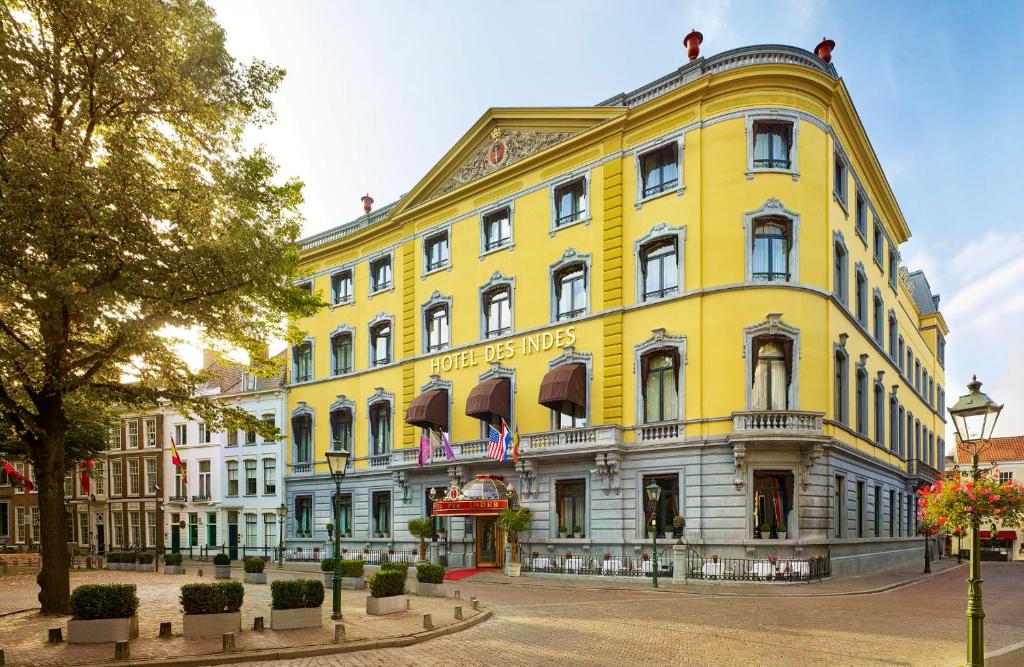 um edifício amarelo numa rua numa cidade em Hotel Des Indes The Hague em Haia