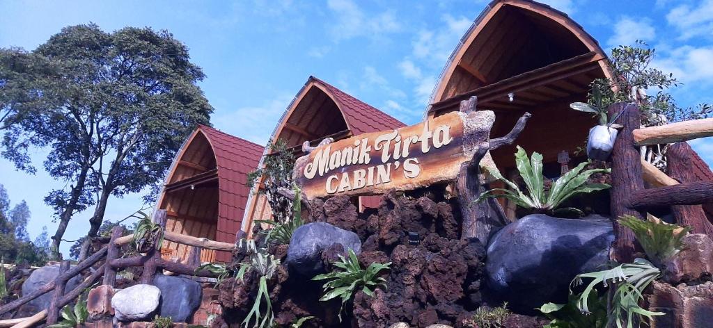 a building with a sign that reads dinosaur find citys at Manik Tirta Cabin's in Kintamani